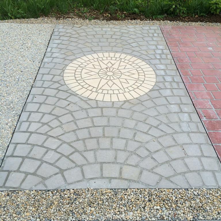 Sol en béton imprimé avec un motif représentant le soleil.