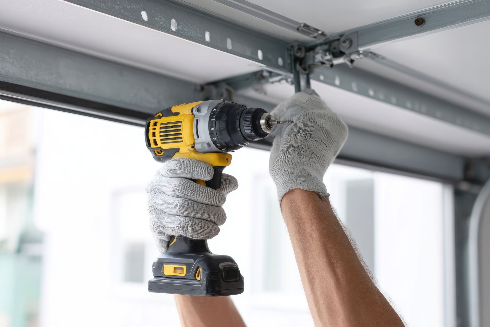 Poseur fixant les rails d'une porte de garage