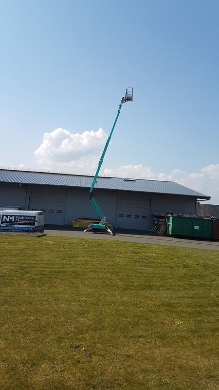 Nacelle élévatrice au-dessus d'un bâtiment industriel