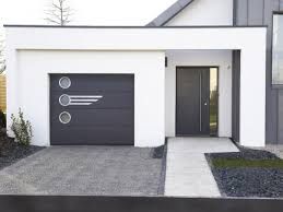 Maison blanche moderne avec porte de garage, porte d'entrée et allée gris foncé