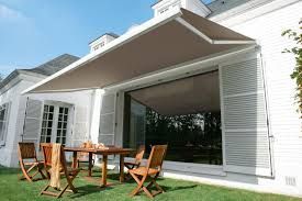 Un auvent beige s'étend au-dessus d'une table et de chaises