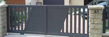 Portail en métal gris avec piliers en brique