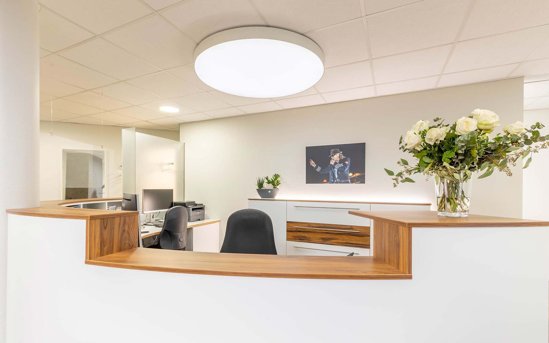 Ein Empfangstresen in einem Büro mit einer Vase mit Blumen darauf.