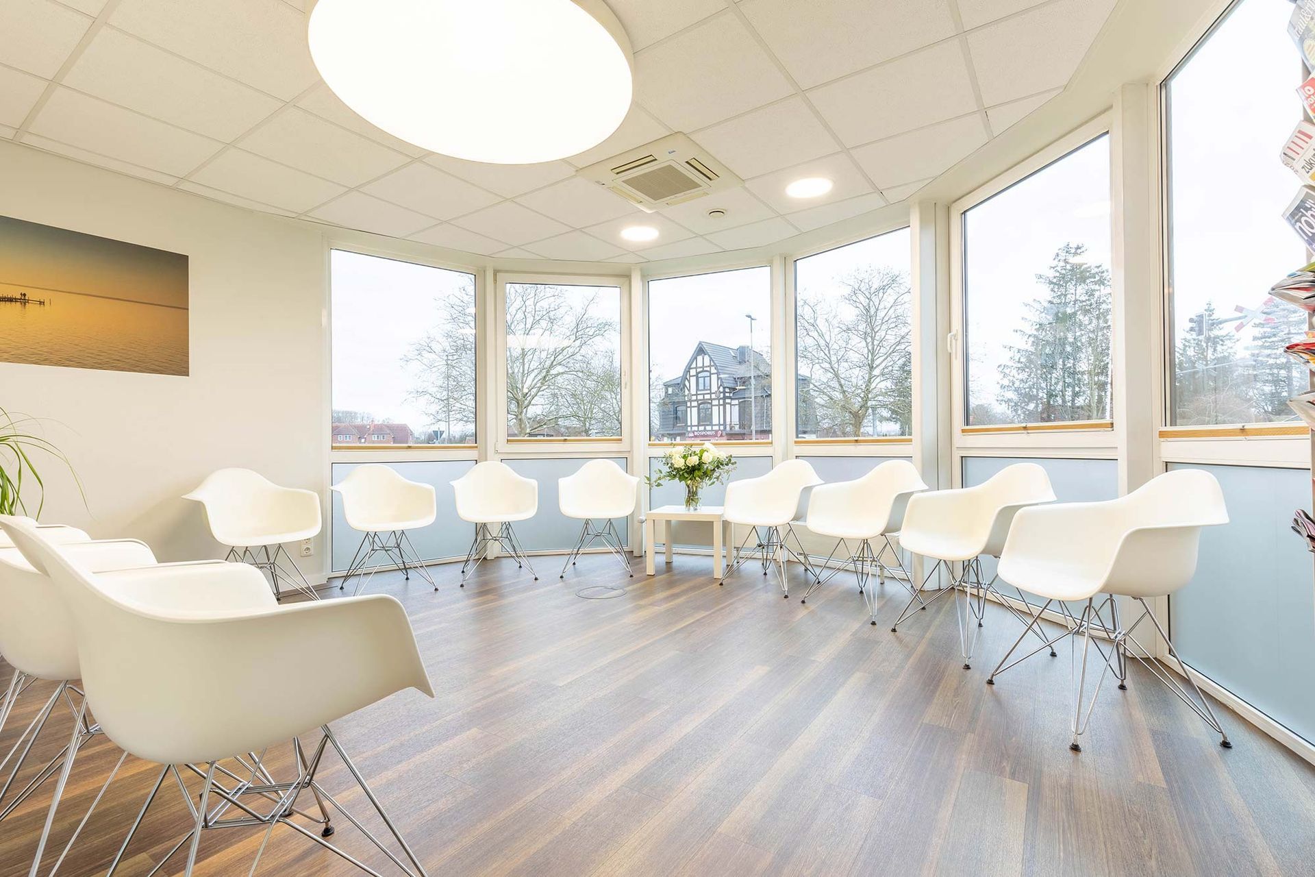 Ein Wartezimmer mit vielen Stühlen und Fenstern.