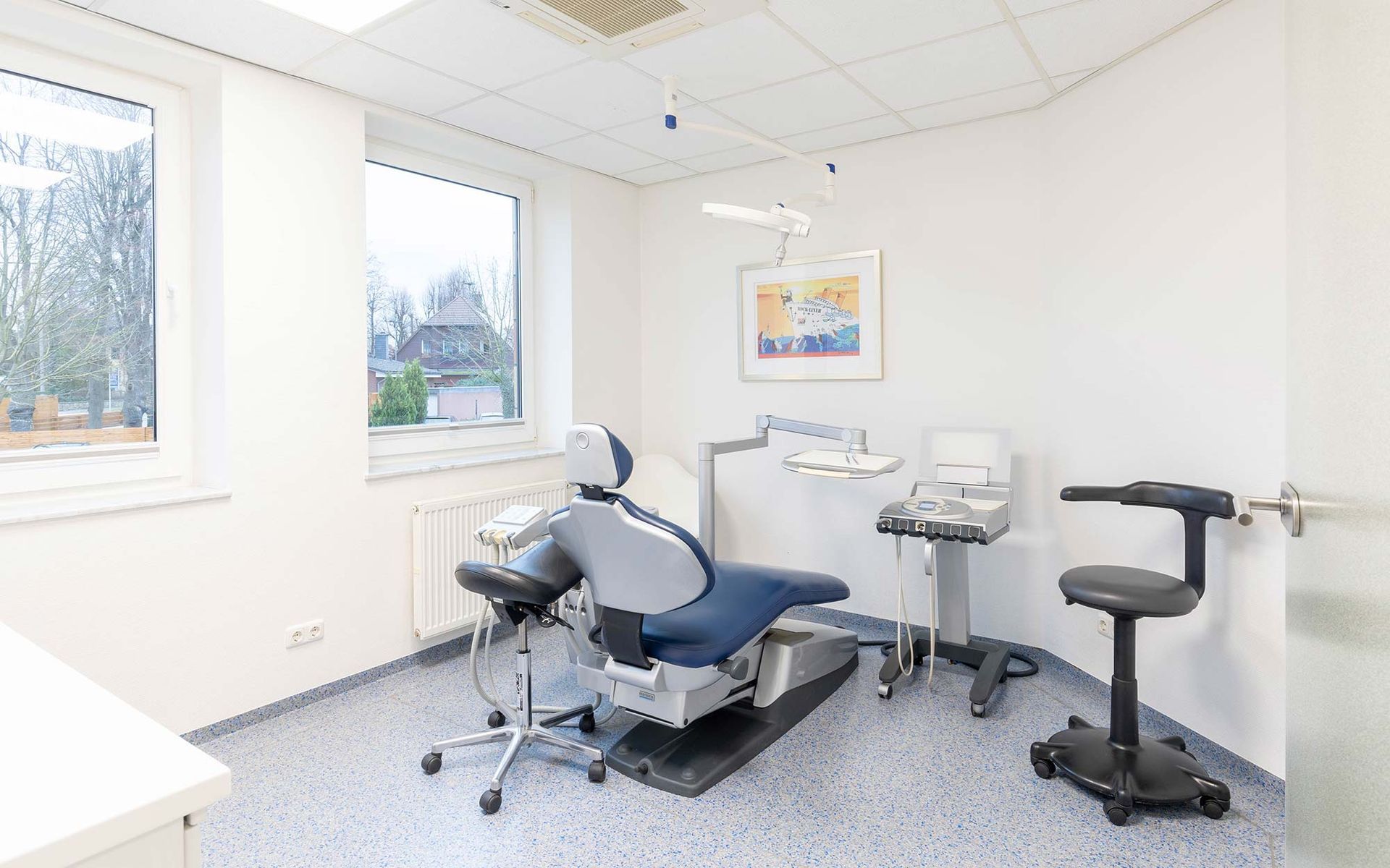 Eine Zahnarztpraxis mit einem Zahnarztstuhl und einem Fenster.