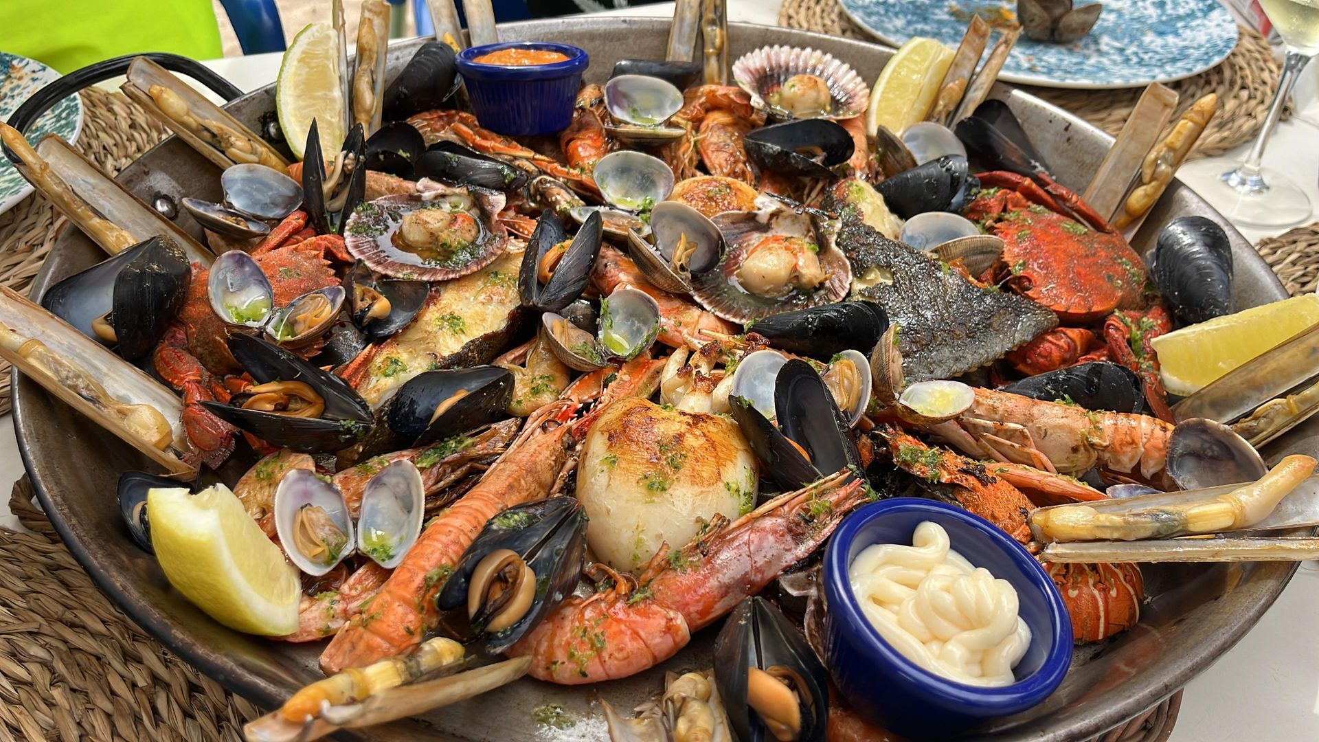 Paella de mariscos en una sartén grande, que incluye almejas, mejillones, gambas, langosta y vieiras.