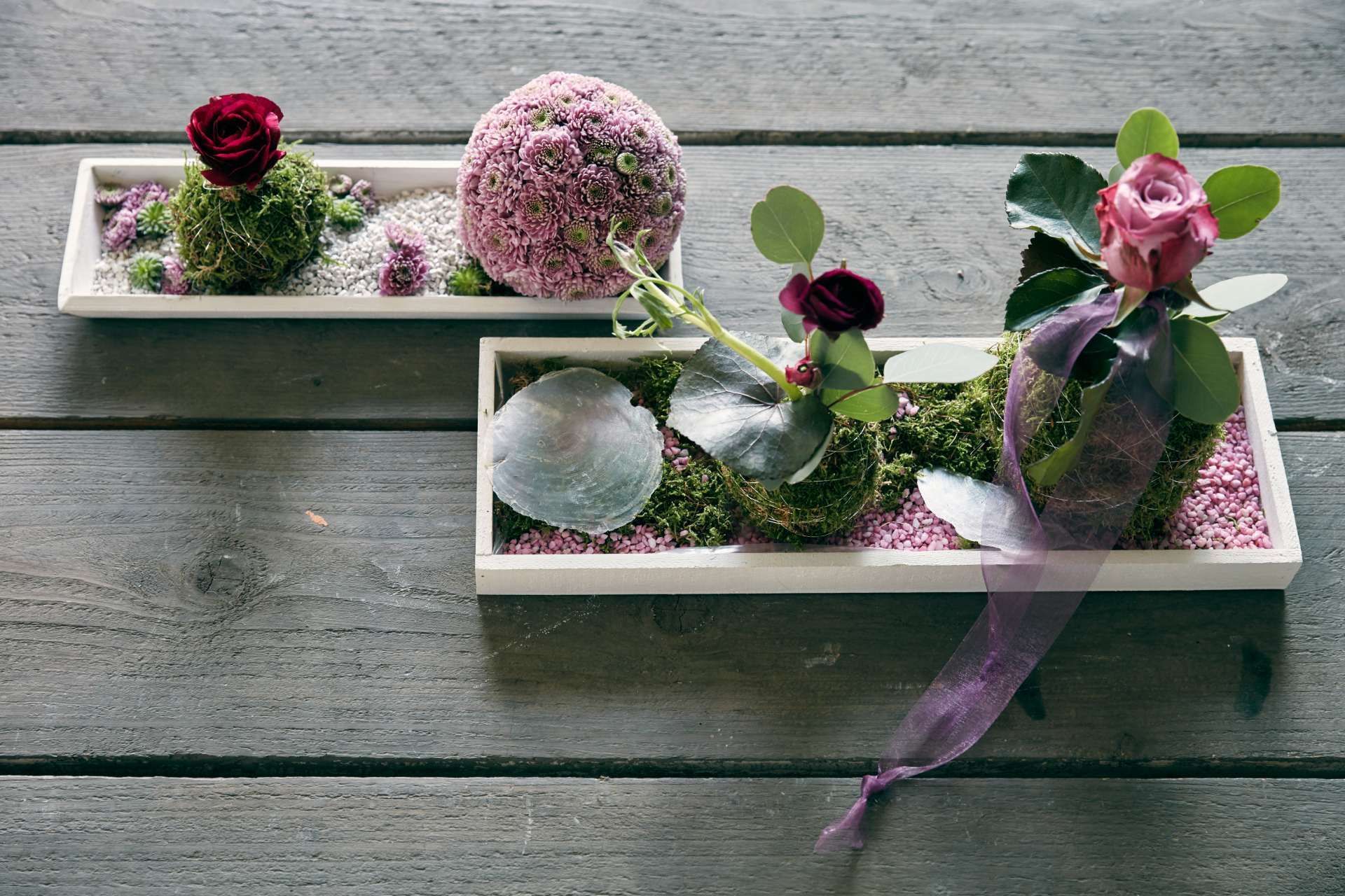 Florale Tischdeko Blumen und Dekosteinen in Holzschiffchen