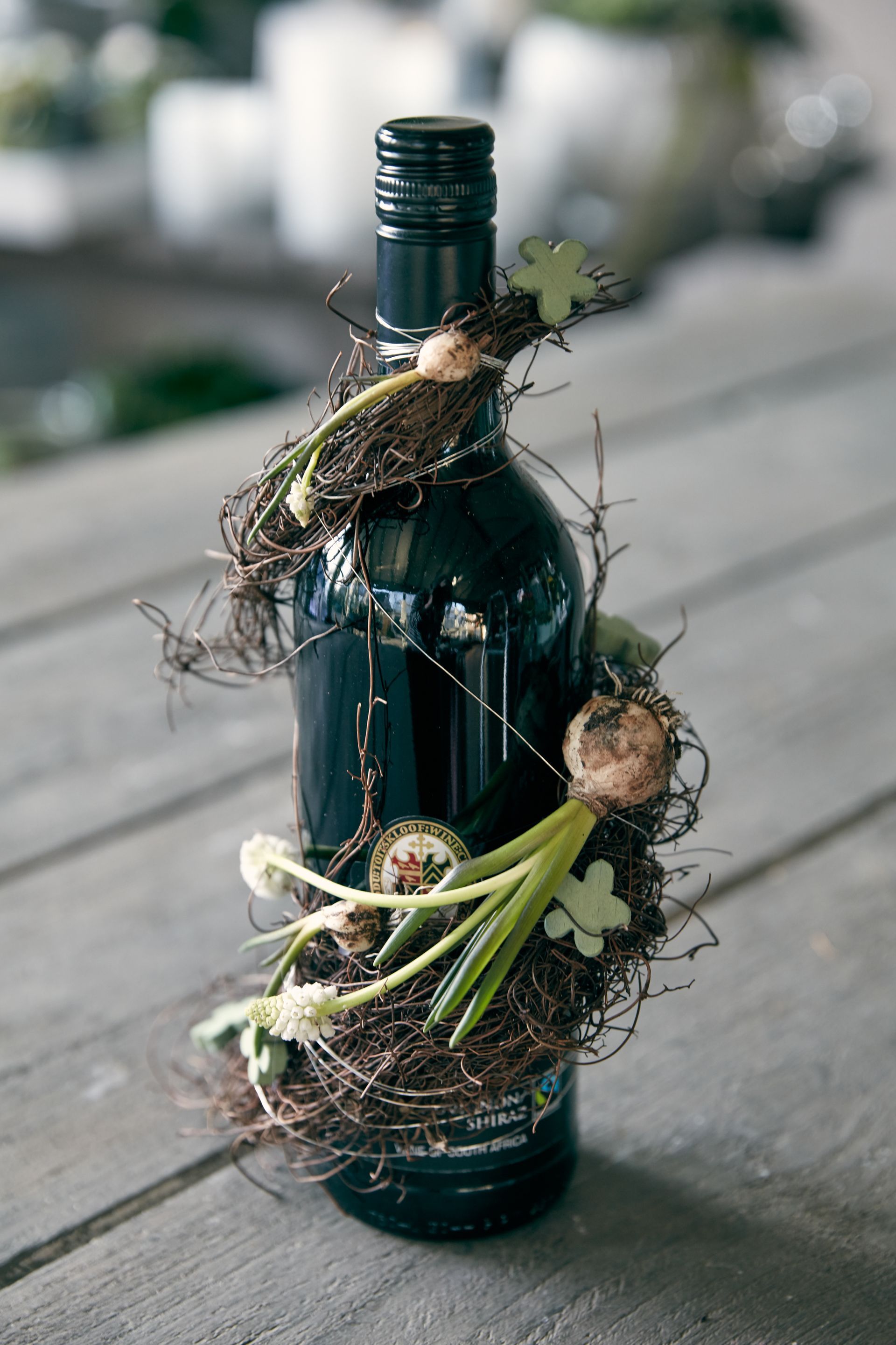 Weinflasche mit floraler Deko als Geschenk