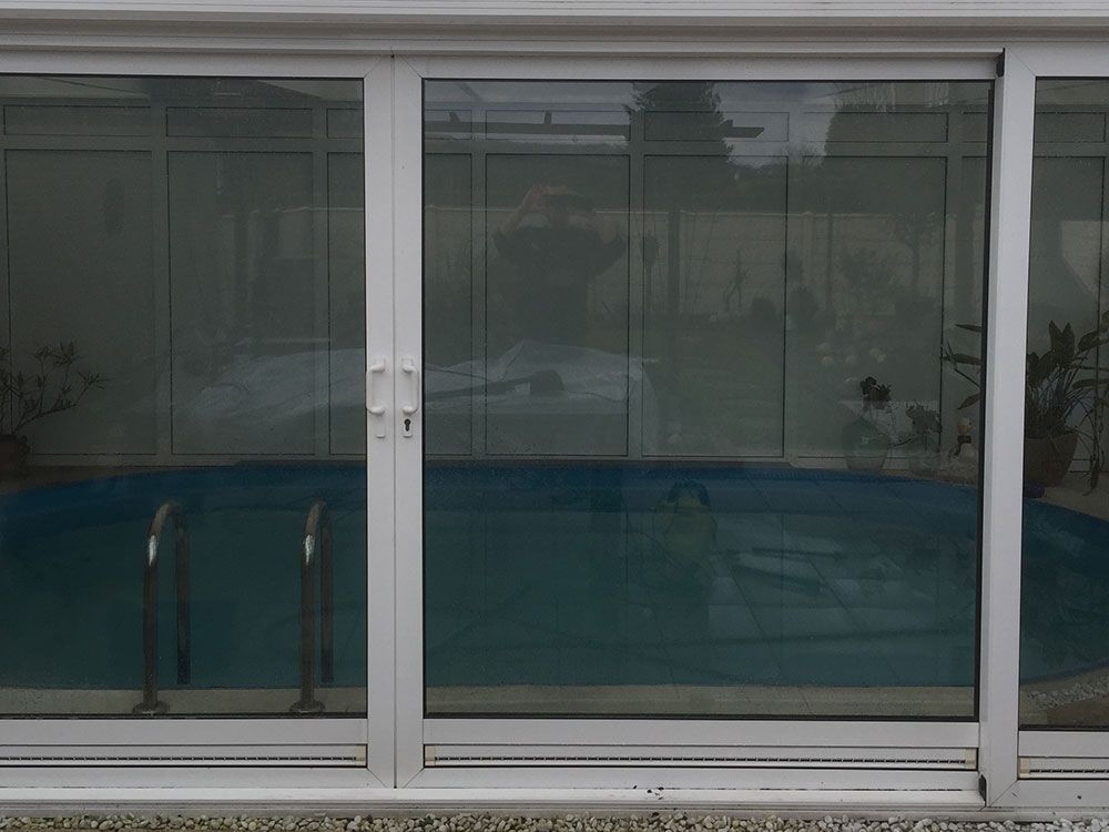 Ein Swimmingpool befindet sich hinter einer Glasschiebetür