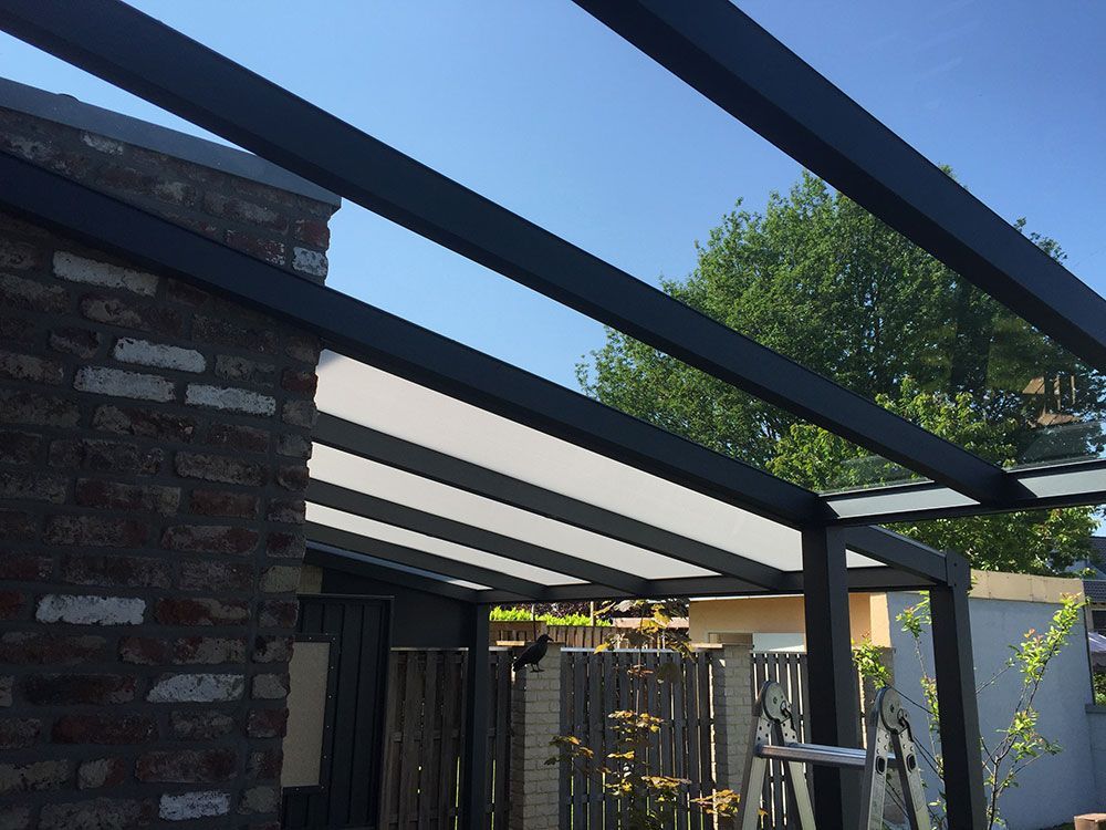 An der Seite eines Backsteingebäudes wird eine Pergola errichtet