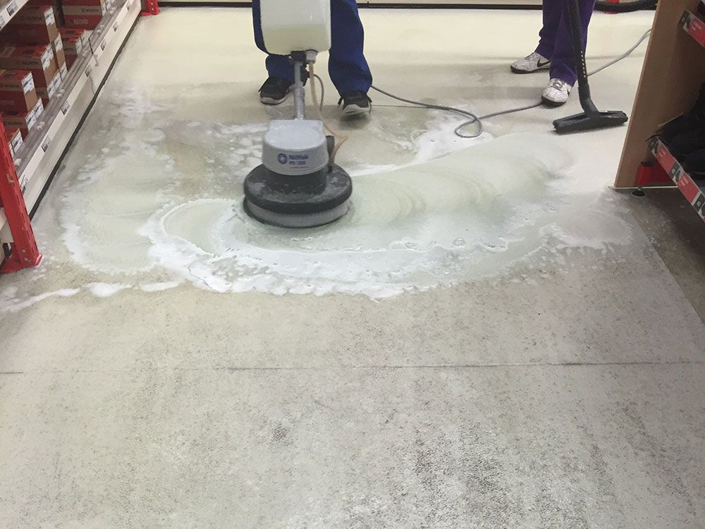 Eine Person benutzt eine Maschine, um einen Boden zu reinigen