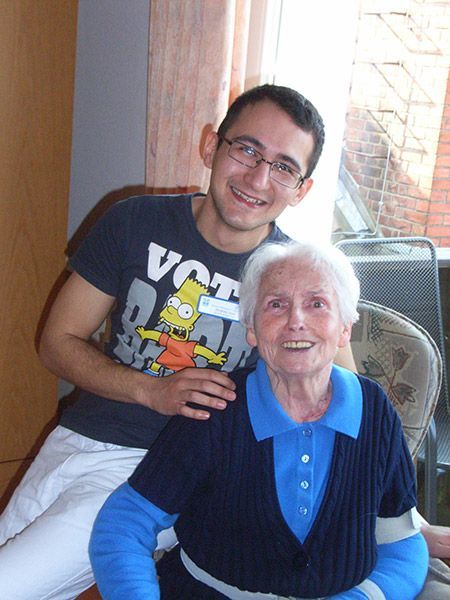 Ein Mann in einem Bart Simpson-Shirt sitzt neben einer älteren Frau