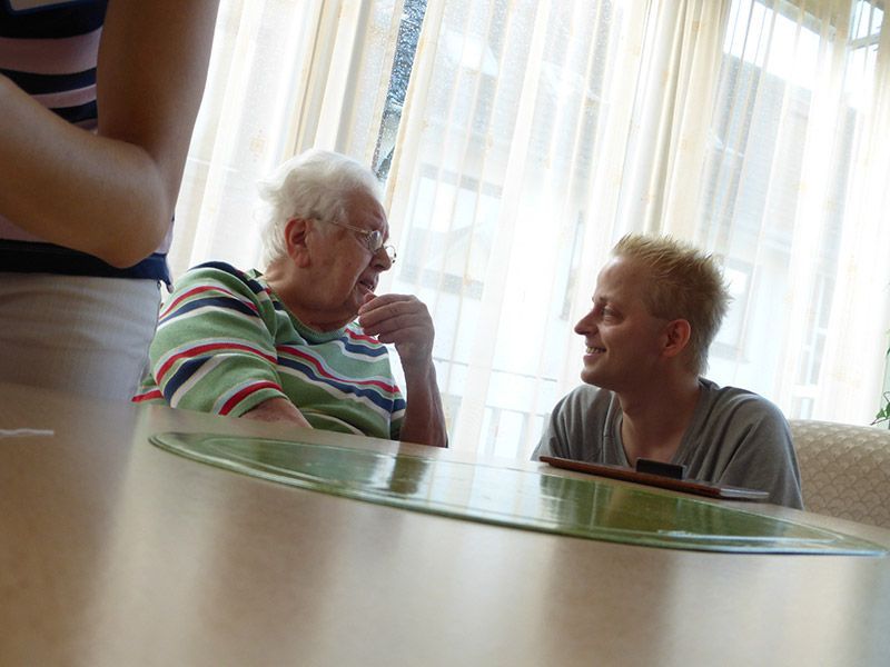 Zwei Personen sitzen an einem Tisch und unterhalten sich.