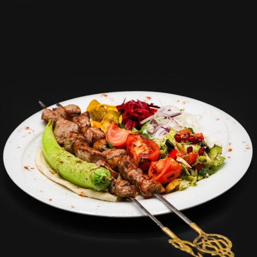 Ein Teller mit Fleischspiessen und Gemüse. Foto von Mama's Grillhaus.