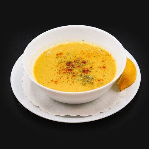 Eine Schüssel Suppe mit einer Zitronenscheibe auf einem Teller. Foto von Mama's Grillhaus.