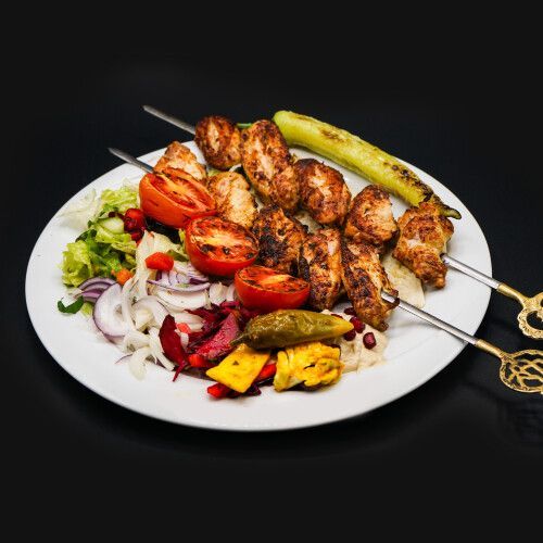 Ein Teller mit Fleischspiessen und Gemüse. Foto von Mama's Grillhaus.