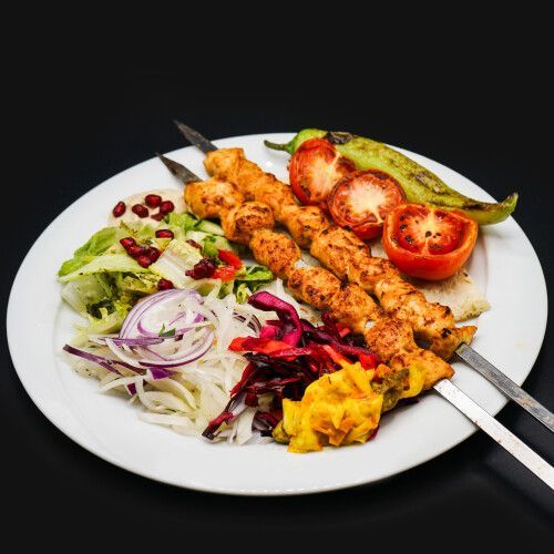 Ein Teller mit Fleischspiessen und Gemüse. Foto von Mama's Grillhaus.