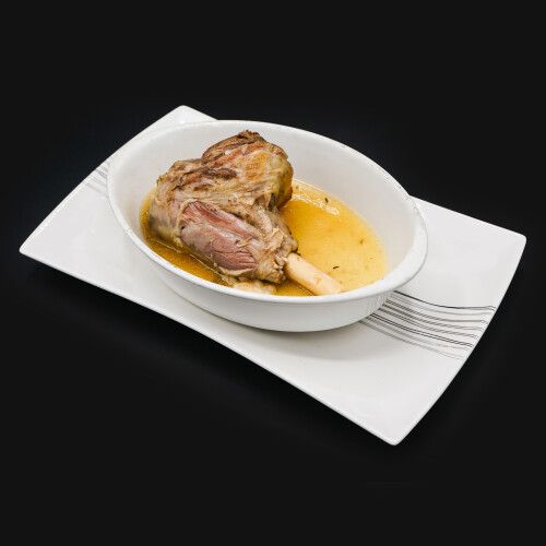 Ein Teller mit einer Schüssel Fleisch und Sosse. Foto von Mama's Grillhaus.