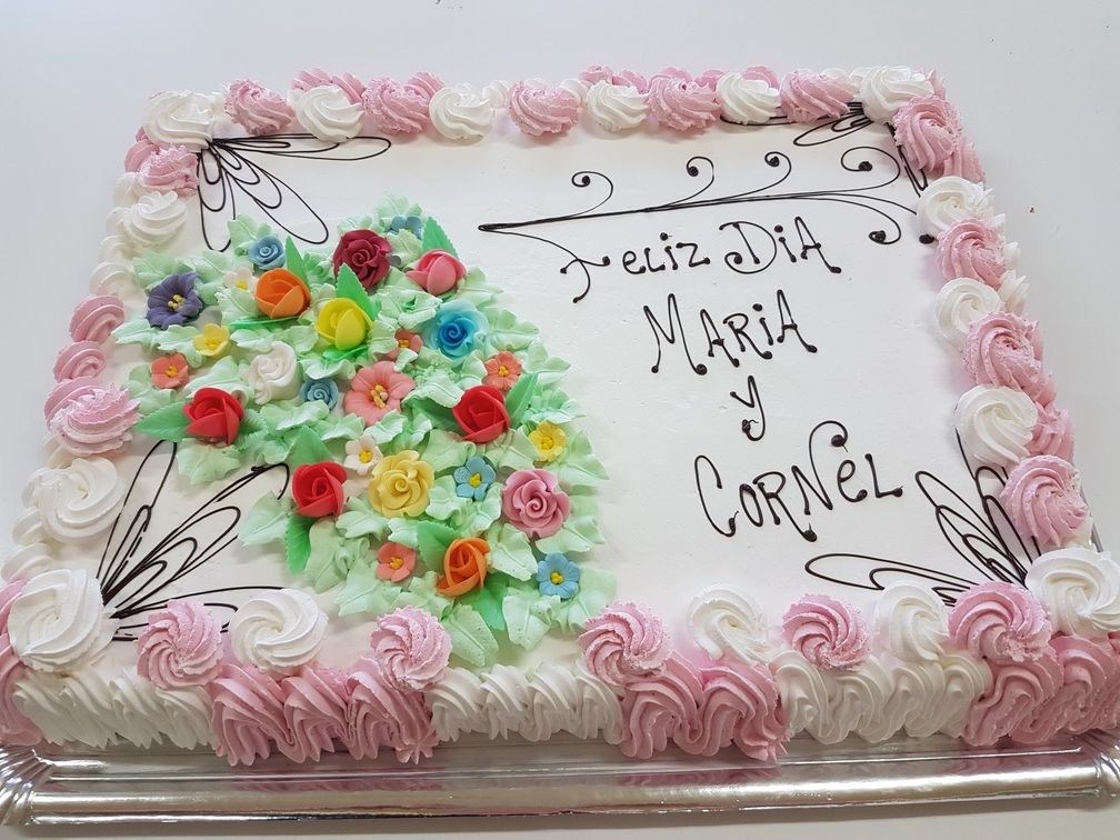 Pastel decorado con flores, glaseado rosa y blanco y la frase