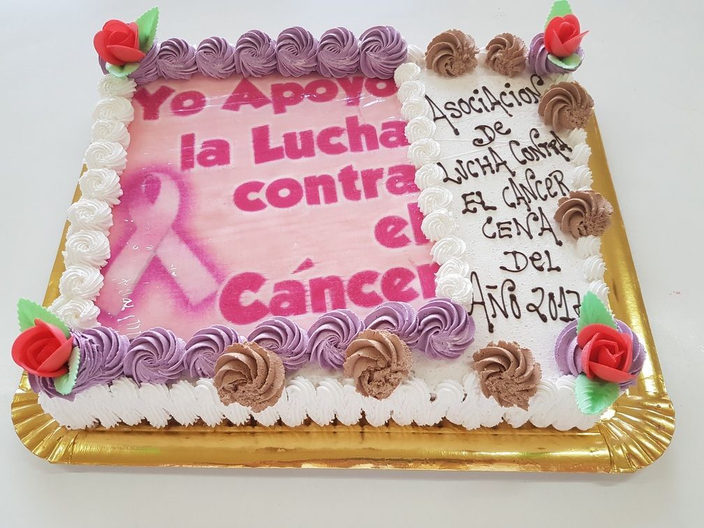 Pastel decorado con texto en apoyo a la lucha contra el cáncer. Cinta rosa, rosas y varios diseños de glaseado.