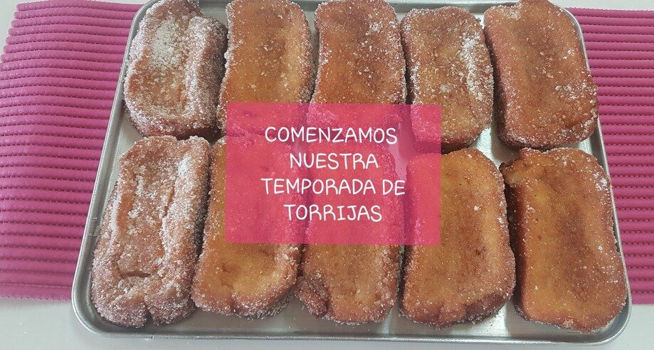 A tray of golden, sugar-dusted torrijas (Spanish French toast) with text