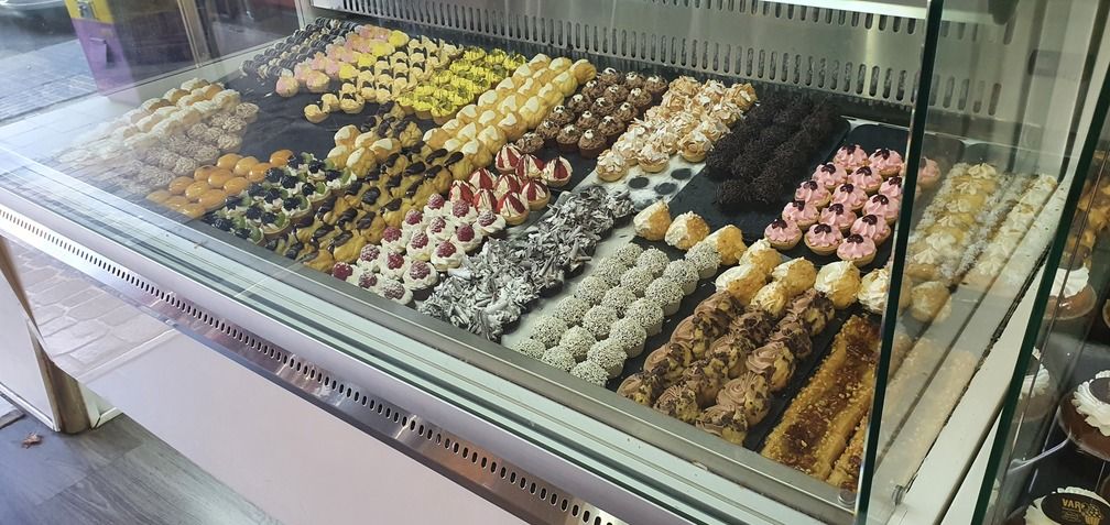 Vitrina llena de diversos pasteles en una panadería.