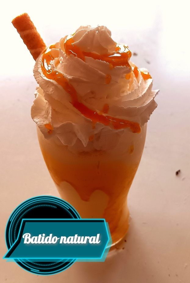 Vaso de batido amarillo con crema batida, un toque de caramelo y una oblea. Etiqueta