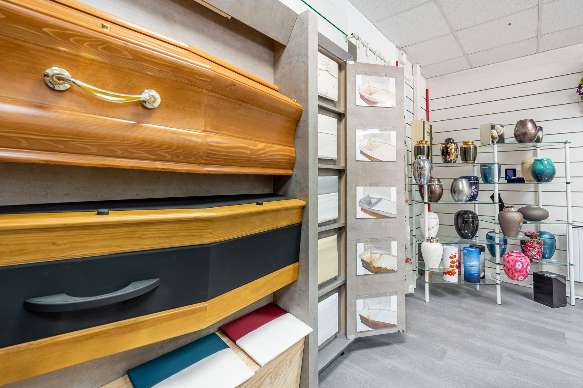 Des cercueils et urnes funéraires exposés dans des pompes funèbres.