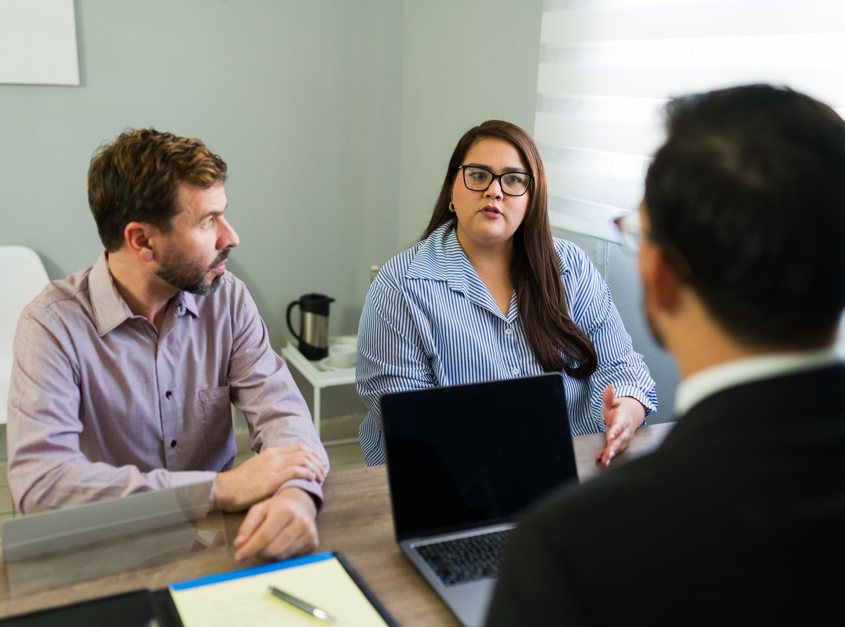 Un jeune couple discute avec un conseiller.