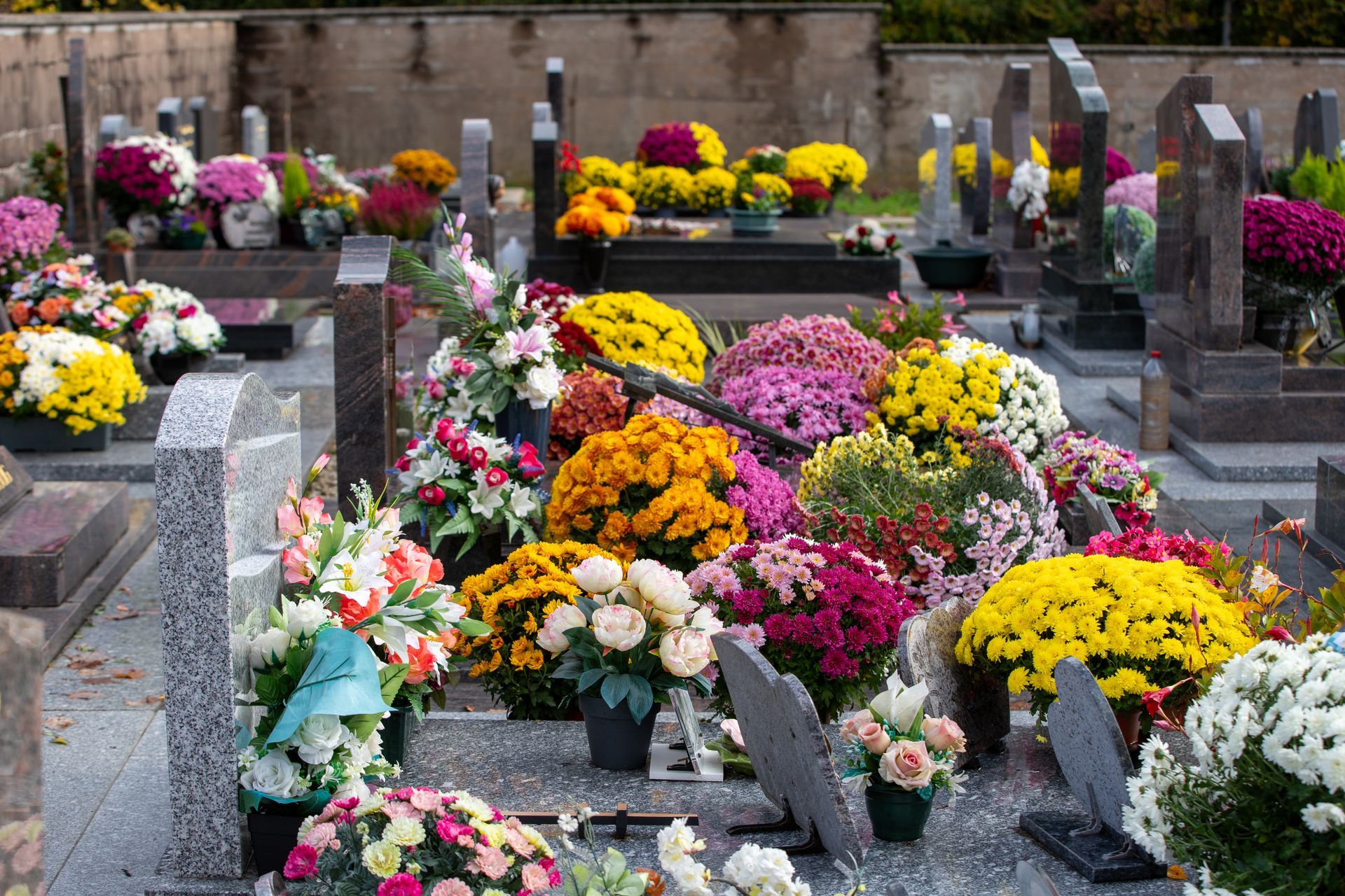 Des pierres tombales fleuries dans un cimetière.