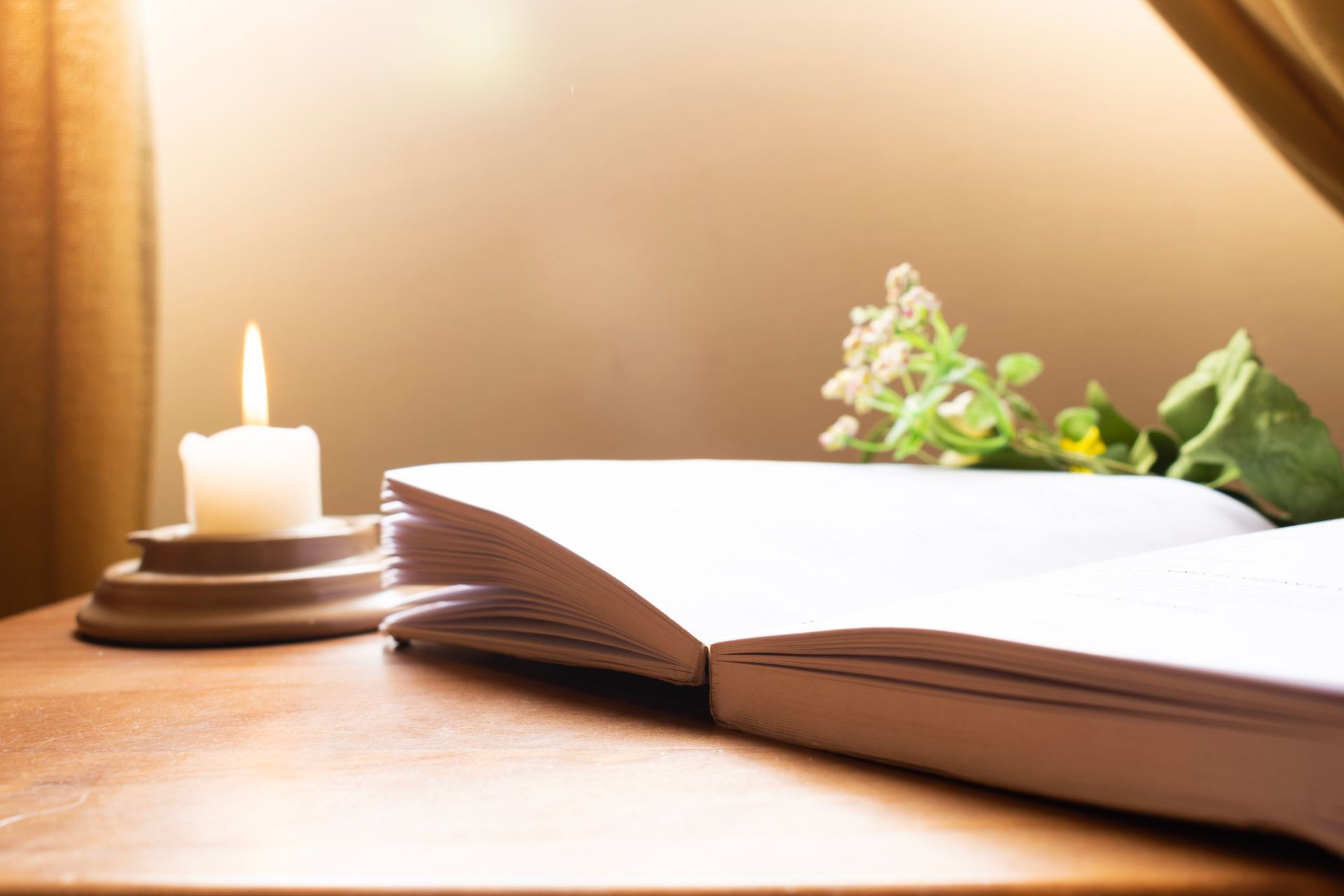 Un livre ouvert avec une bougie située à côté.