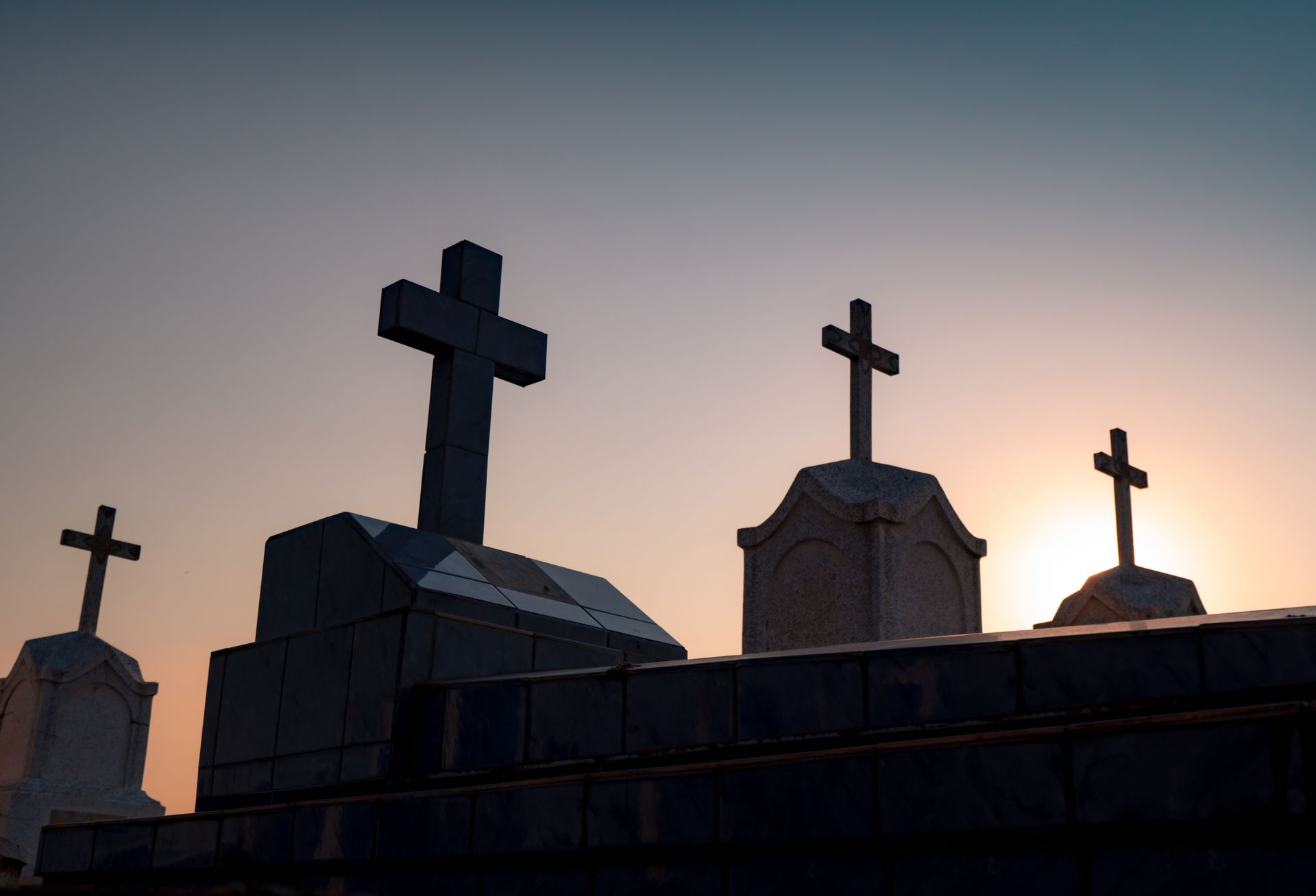 Silhouettes de croix sur des tombes dans un cimetière.