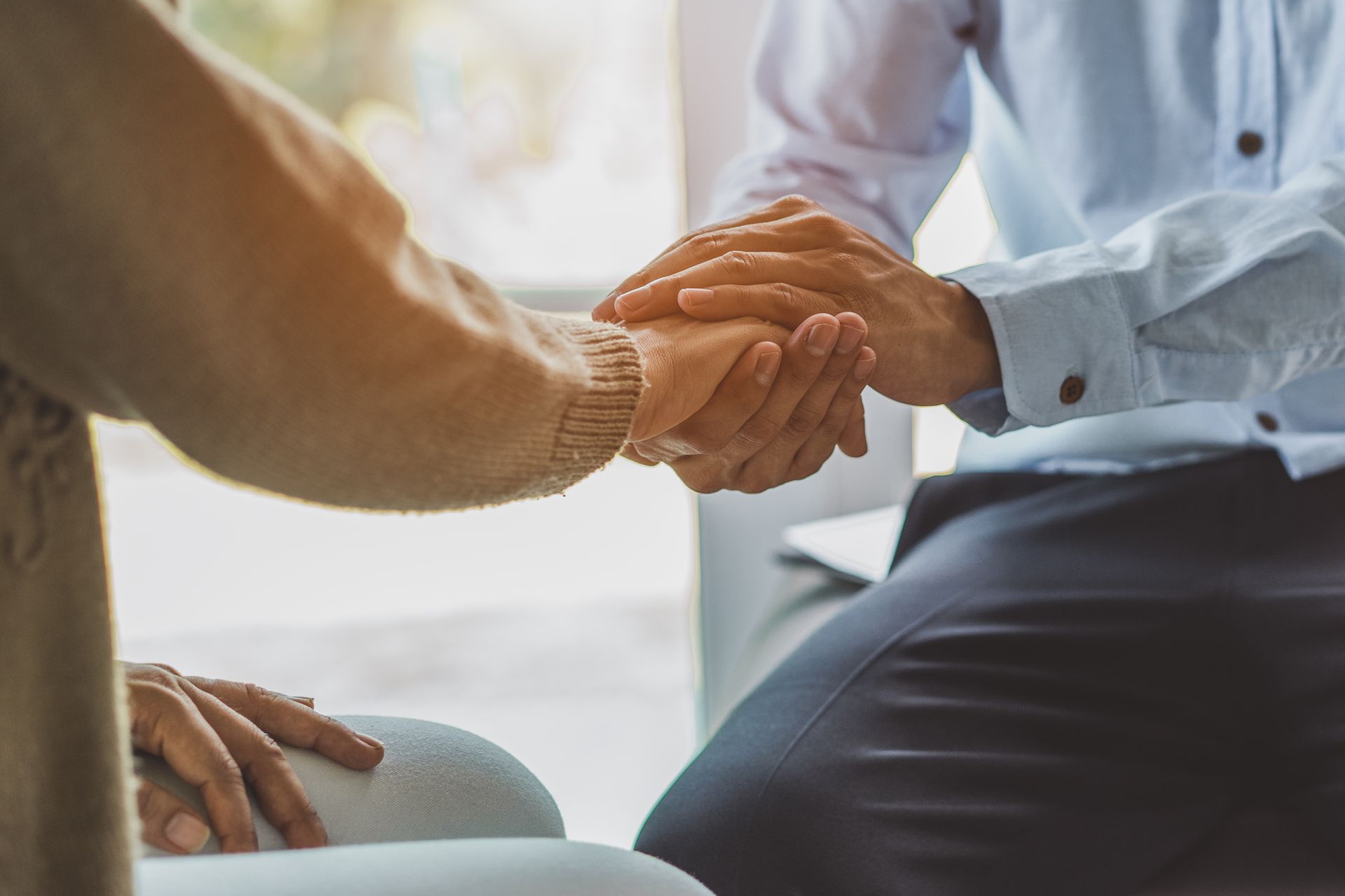 Une personne qui tient la main de celle située en face.