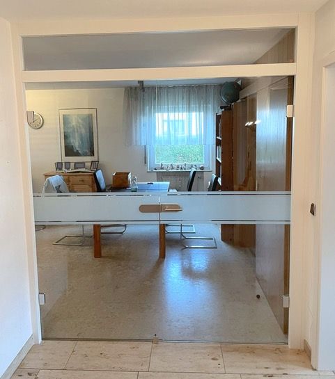 ein Esszimmer mit Tisch und Stühlen und einem Fenster