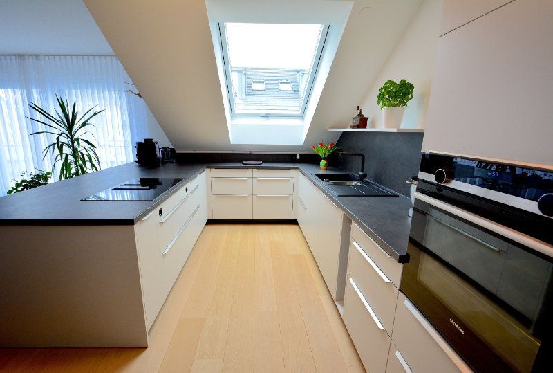 eine Küche mit weißen Schränken und einer schwarzen Arbeitsplatte