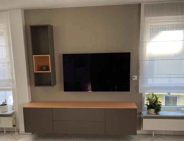 ein Wohnzimmerschrank mit einem Flachbildfernseher an der Wand