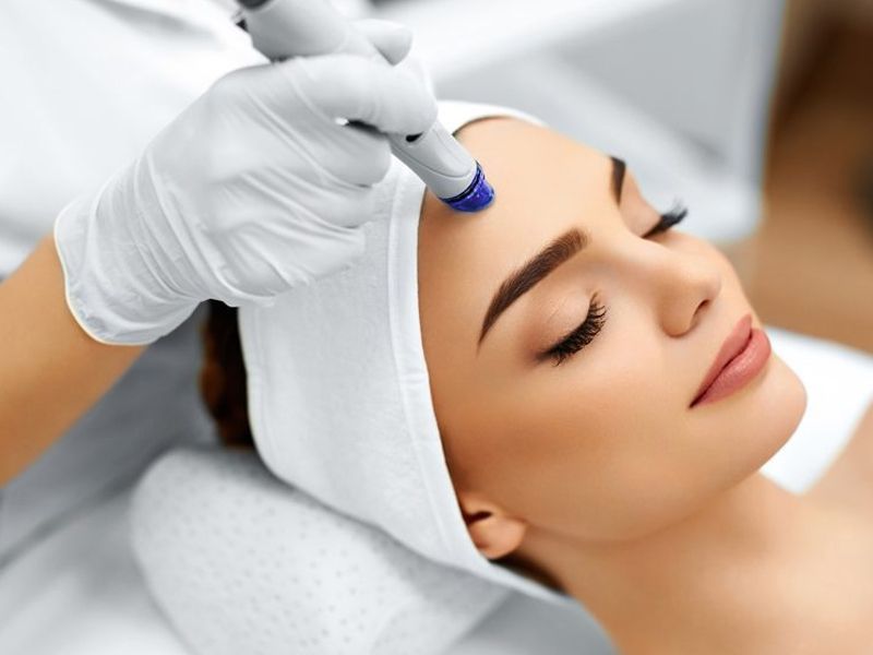 Una mujer recibe un tratamiento facial con un dispositivo portátil.