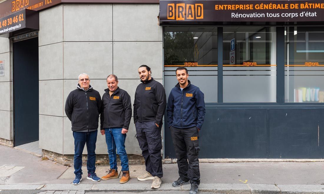 Artisan des chez BRAD SAS posant devant la façade de l'entreprise