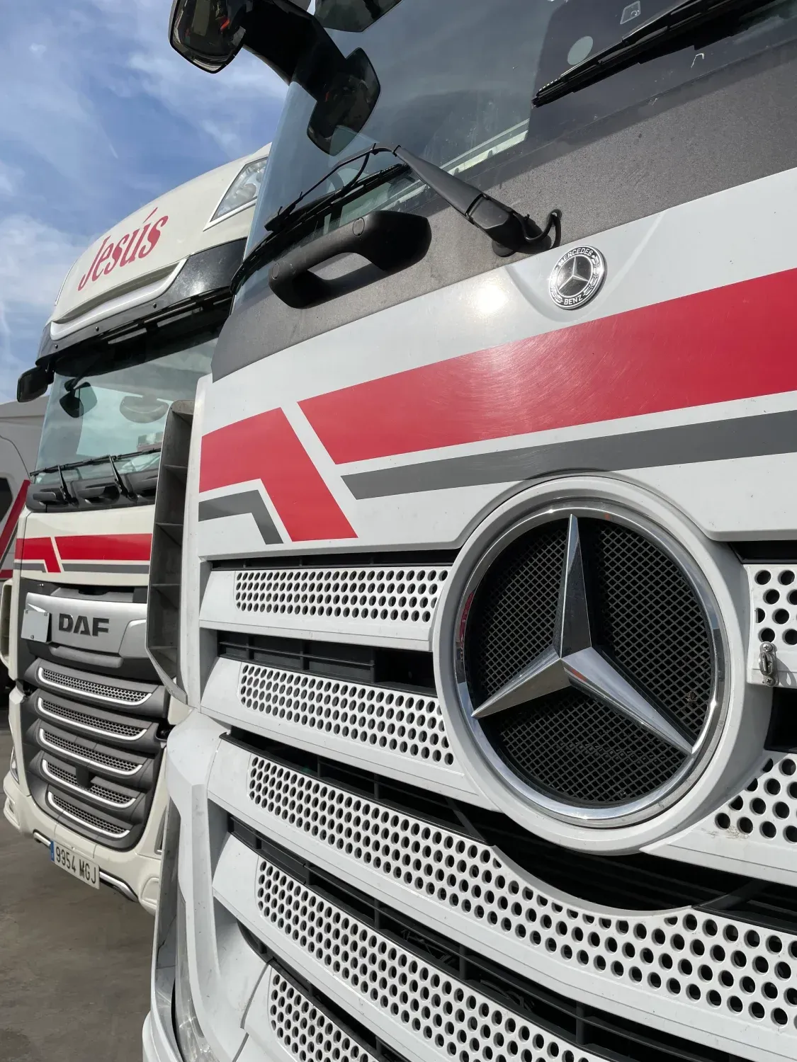 Una fila de camiones Mercedes están estacionados uno al lado del otro.