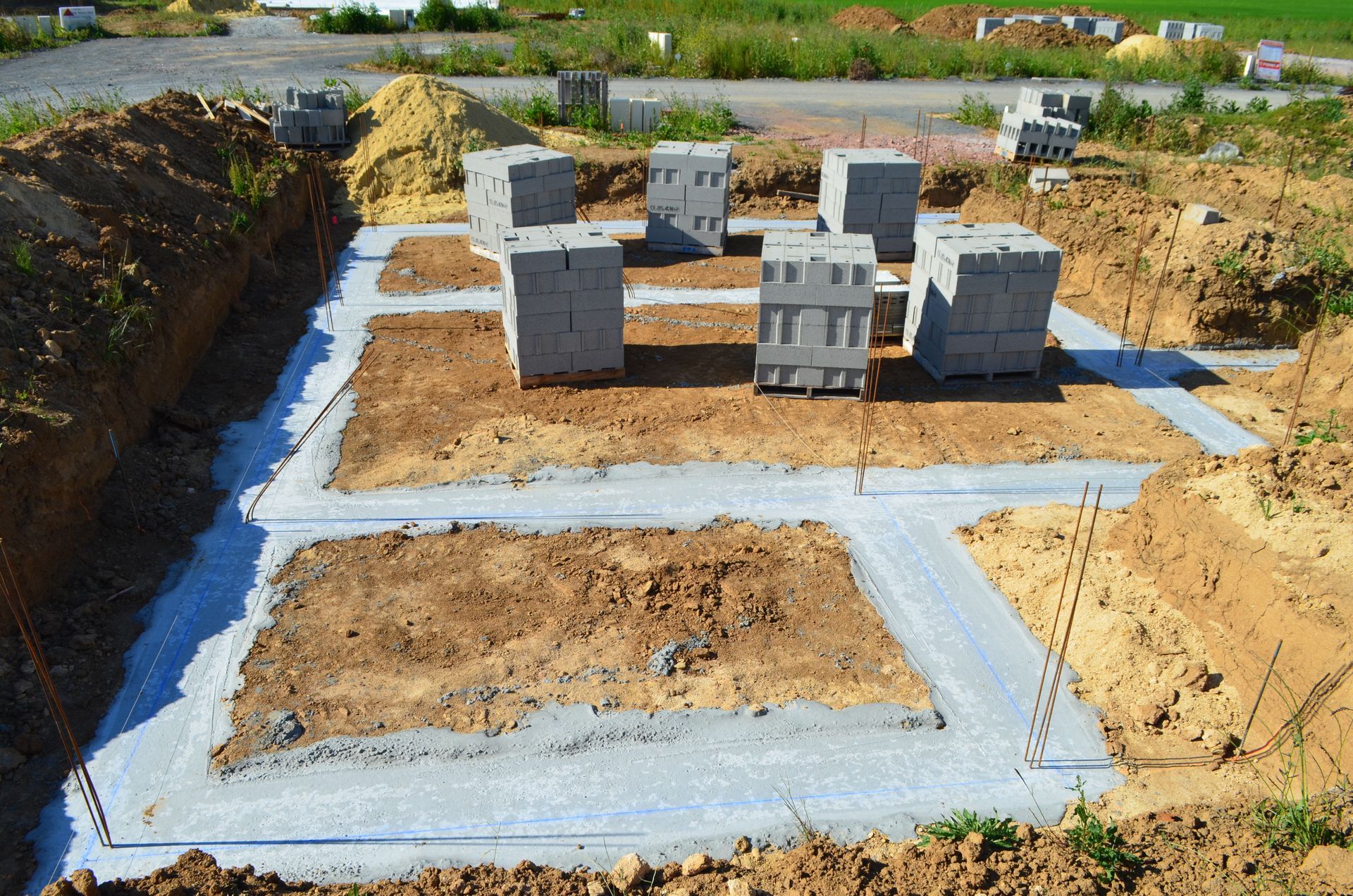 Chantier de construction avec fondations et blocs de béton.