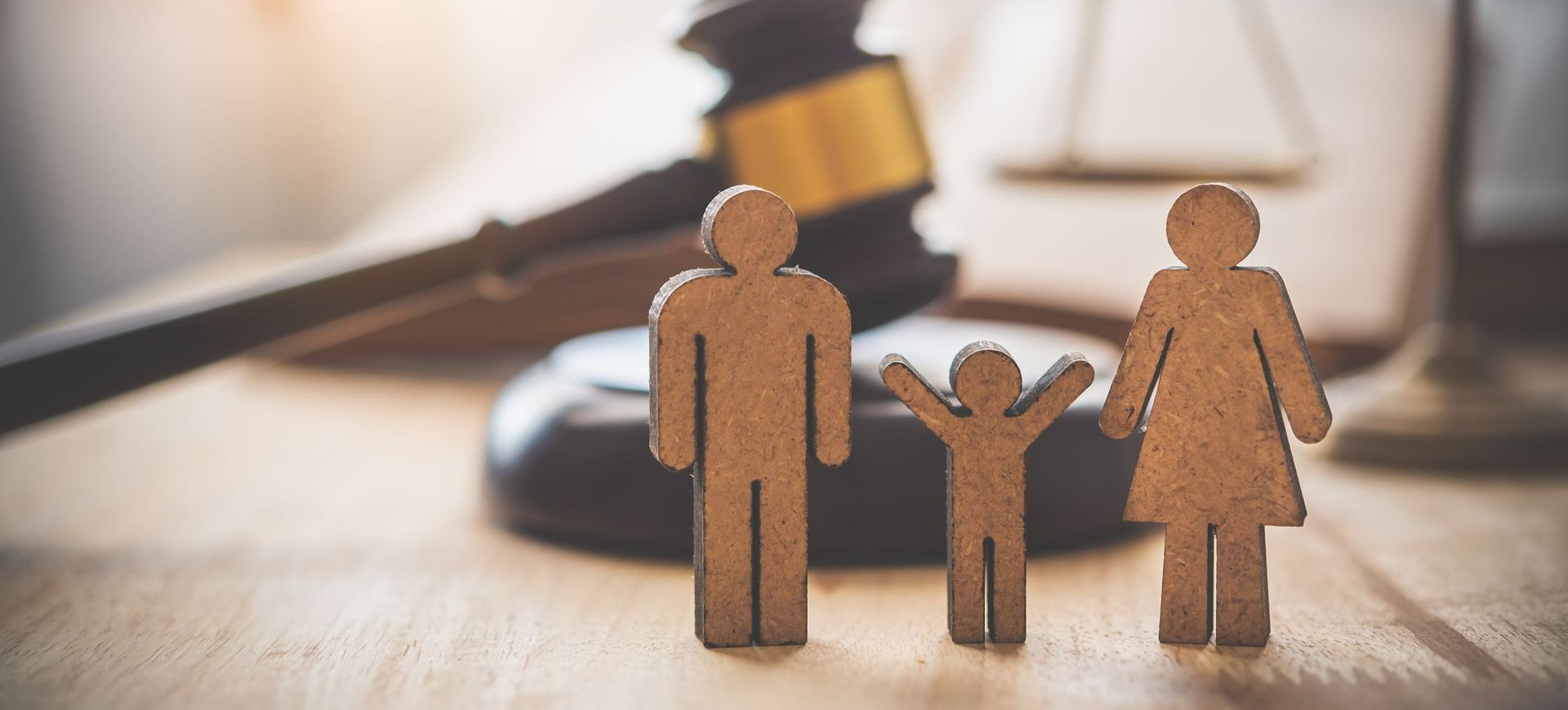 Bonshommes de bois représentant une famille et marteau de juge en arrière-plan