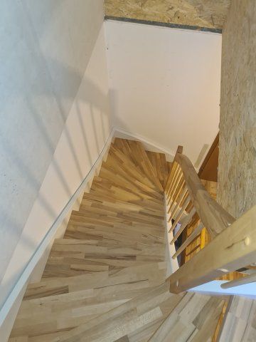 Hölzerne Wendeltreppe mit Handlauf, von oben gesehen.