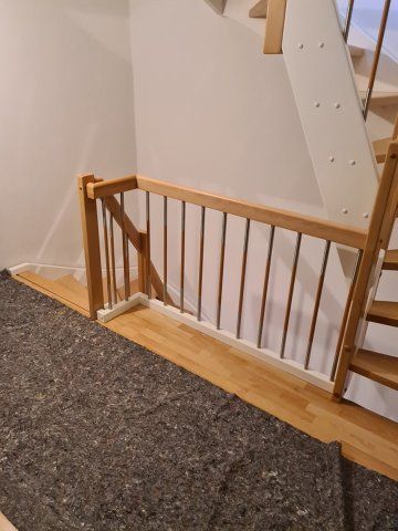 Holztreppe mit Geländer, Metallstangen und Hartholzboden.