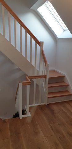 Holztreppe mit weißem Geländer, Holzstufen und -boden, Oberlicht.