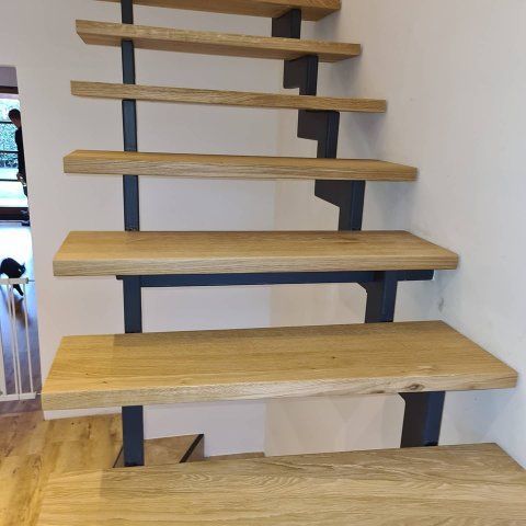 Hölzerne Treppenstufen, die an schwarzen Metallstützen befestigt sind.