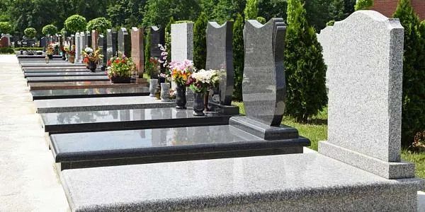 Una hilera de tumbas en un cementerio con flores en ellas.