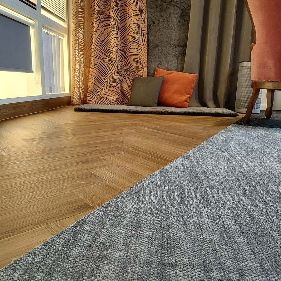 ein Wohnzimmer mit einem Holzboden, einem Teppich und einem Stuhl - Aktuelles von Koke Raumausstattung - Tobias Liebrand - vor Ort in Senden und Lüdinghausen