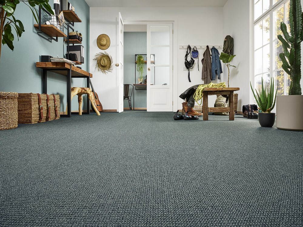 ein Wohnzimmer mit einem grauen Teppichboden und einer Bank - Bodenbeläge von Koke Raumausstattung - Tobias Liebrand - vor Ort in Senden und Lüdinghausen