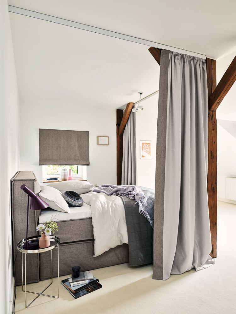 ein Schlafzimmer mit einem Bett und einem Tisch - Gardinen von Koke Raumausstattung - Tobias Liebrand - vor Ort in Senden und Lüdinghausen