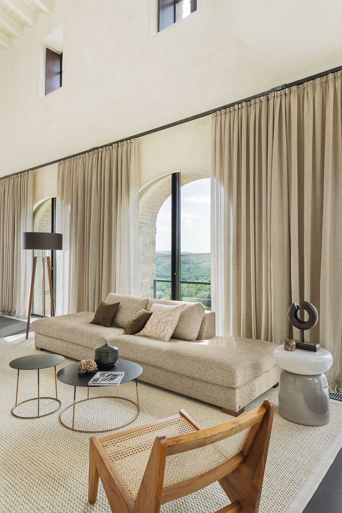 ein Wohnzimmer mit einer Couch , einem Stuhl , einem Tisch und einem großen Fenster - Gardinen von Koke Raumausstattung - Tobias Liebrand - vor Ort in Senden und Lüdinghausen